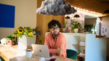 Jonge werknemer op kantoor met een donkere wolk boven het hoofd