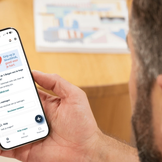 Man voert bloeddrukscan van Helan en Fibricheck uit op smartphone