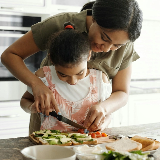 maman et sa fille découpant des légumes dans la cuisine