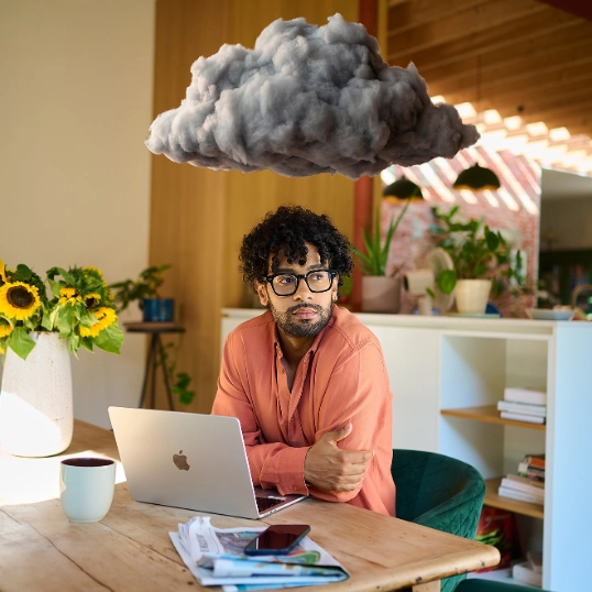 Jonge werknemer op kantoor met een donkere wolk boven het hoofd
