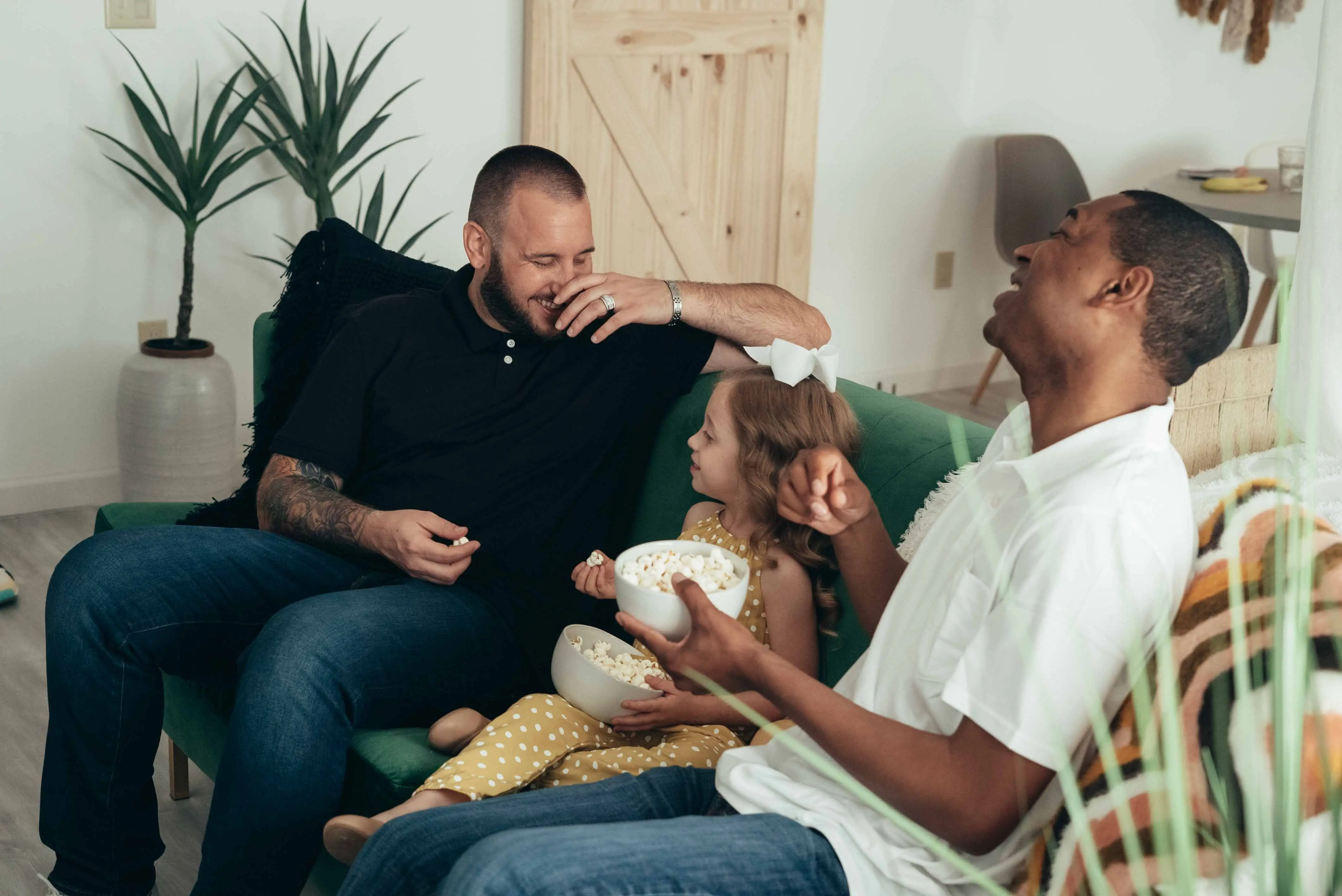adoptievaders met dochter en popcorn in zetel