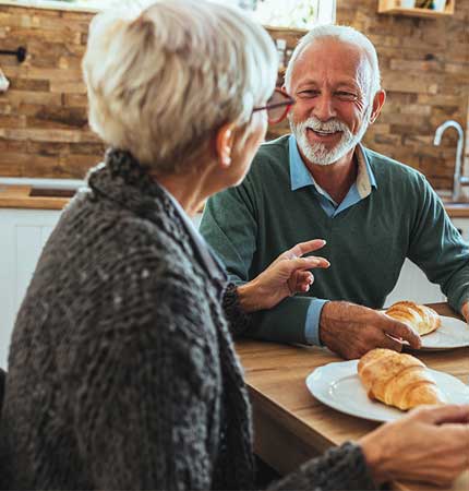 ouder koppel zittend aan eettafel
