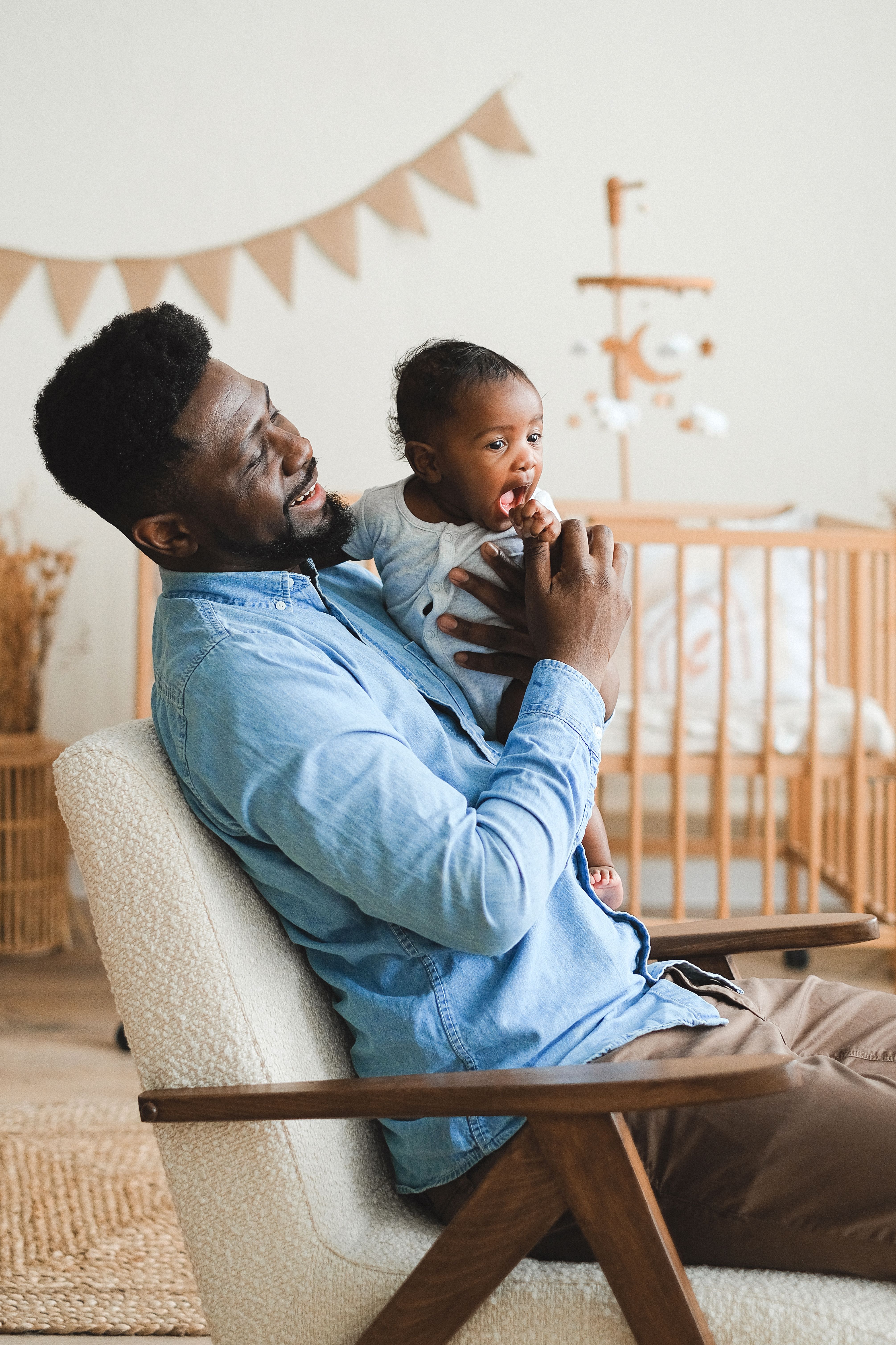 papa met baby op schoot in de kinderkamer
